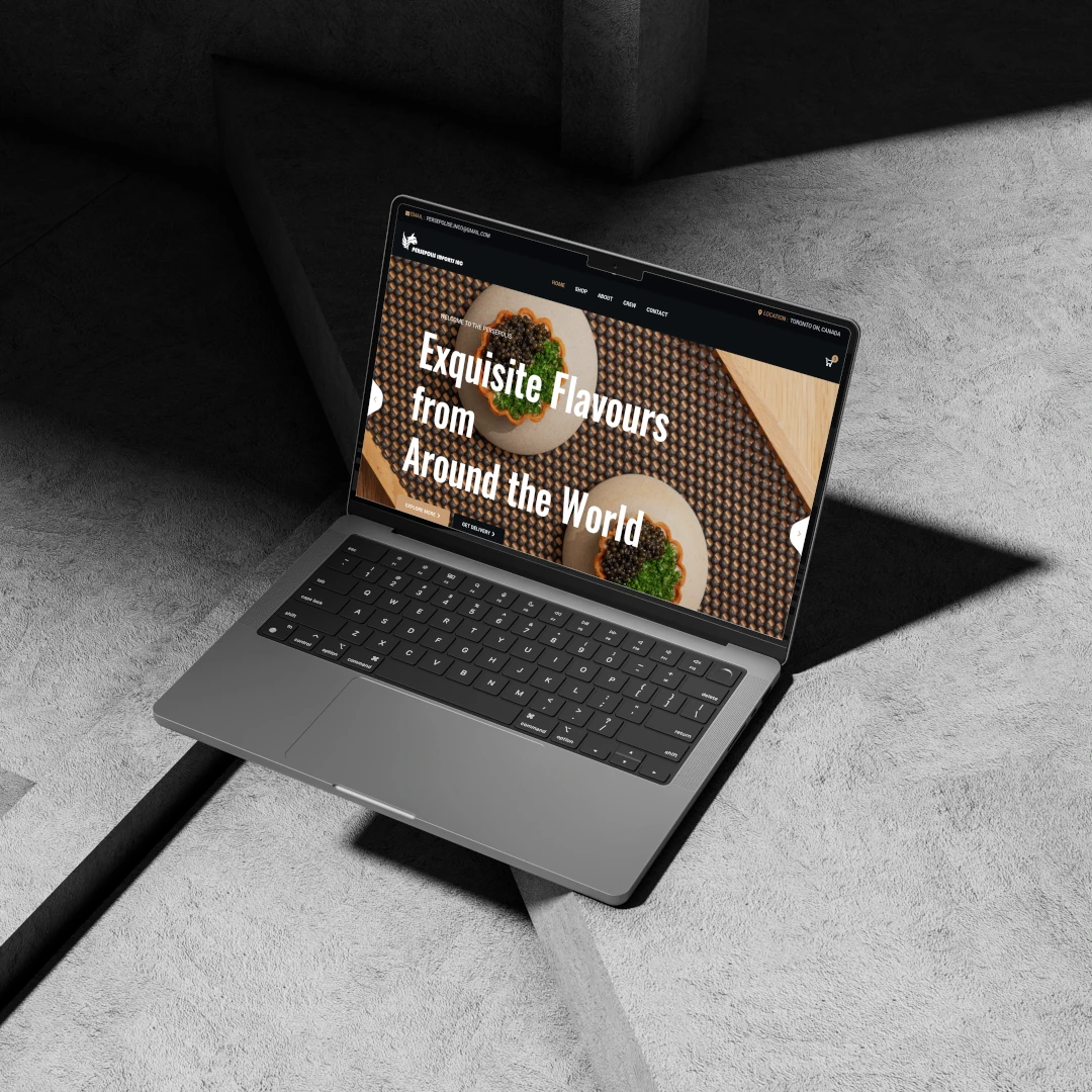 A sleek laptop is open on a textured surface, displaying a website featuring the title "Exquisite Flavours from Around the World." The scene is illuminated with soft lighting, highlighting the laptop's modern design and the geometric patterns of the background.